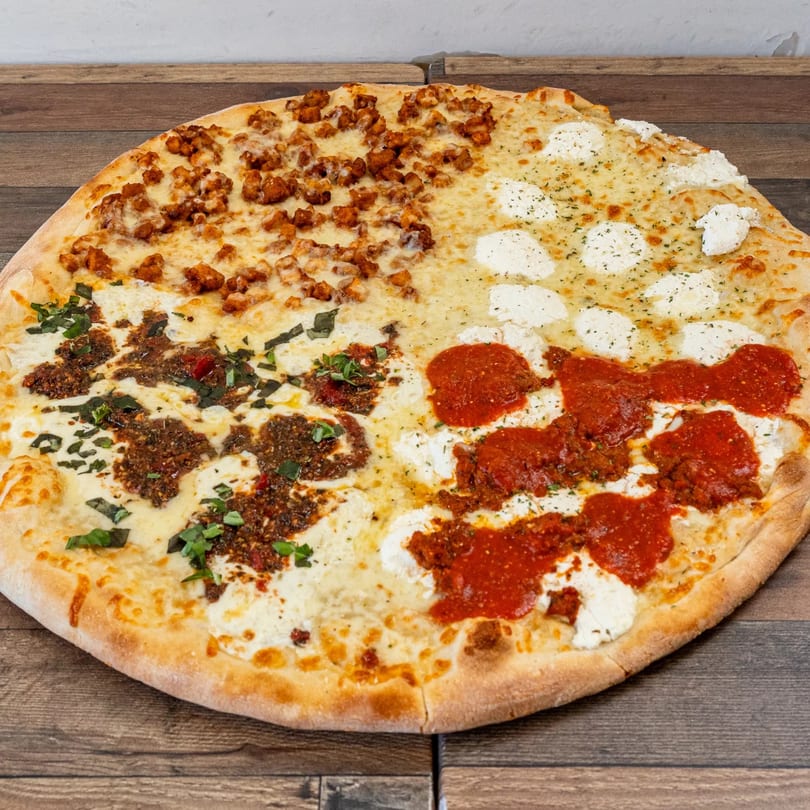 A large Pizza Chop pizza with four different toppings, including chicken, pesto, and marinara.